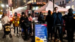 FILE - Patients wait to receive a COVID-19 vaccine booster shot at a mobile vaccination station on 59th Street below Central Park, in New York, Dec. 2, 2021.