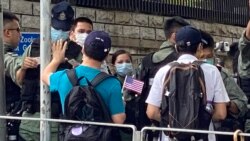 香港市民李先生手持小型的紙製美國國旗，與多名朋友7月4日下午到美國駐港總領事館附近慶祝美國國慶，他們被大批警員截查。(美國之音 湯惠芸拍攝)