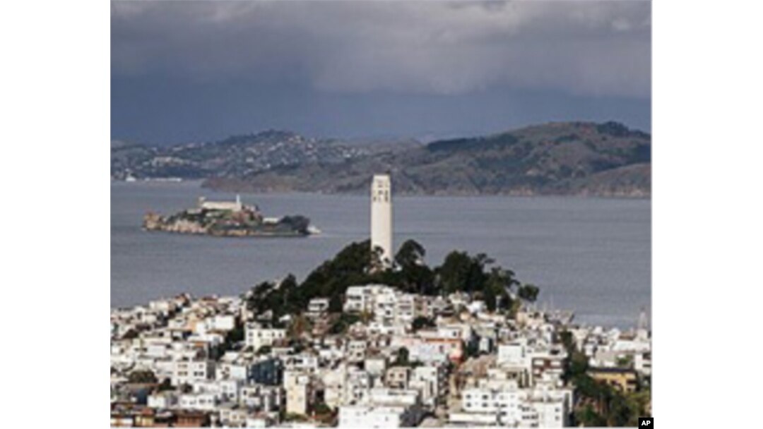 Alcatraz Island looms beyond Coit Tower in San Francisco in the 'Golden Gate,' which is not a bridge but the cold and rapid strait that the bridge crosses nearby.