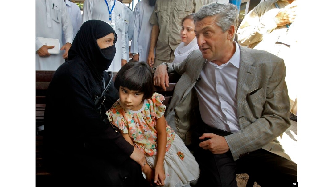 FILE - U.N. High Commissioner for Refugees Filippo Grandi talks to an Afghan refugee woman during his visit to the UNHCR's Repatriation Center in Peshawar, Pakistan, June 23, 2016.