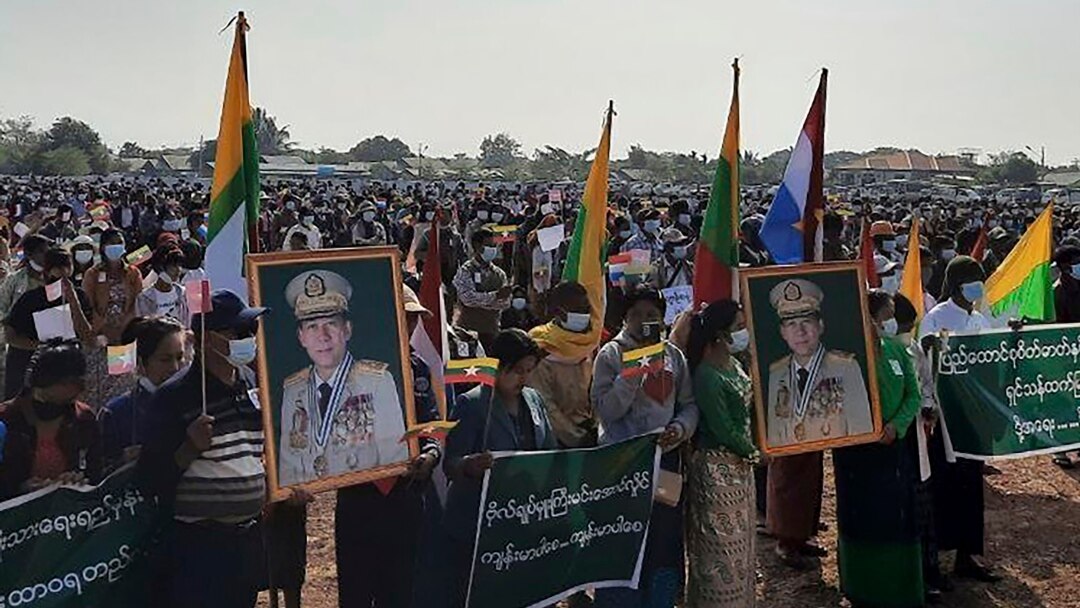 In this image provided by the Military True News Information Team, supporters of the military government hold nationalistic banners and portraits of Senior General Min Aung Hlaing, chairman of the State Administration Council, during a rally, Feb. 1, 2022 in Naypyitaw, Myanmar.