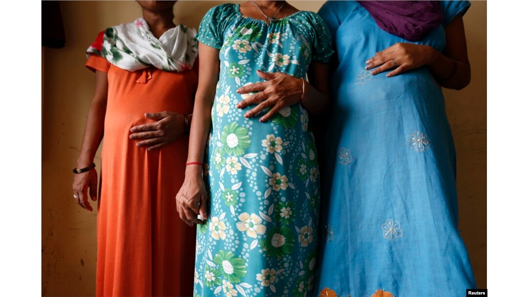 FILE - Surrogate mothers (L-R) Daksha, 37, Renuka, 23, and Rajia, 39, pose for a photograph inside a temporary home for surrogates provided by Akanksha IVF centre in Anand town, about 70 km (44 miles) south of the western Indian city of Ahmedabad, Aug. 27, 2013.