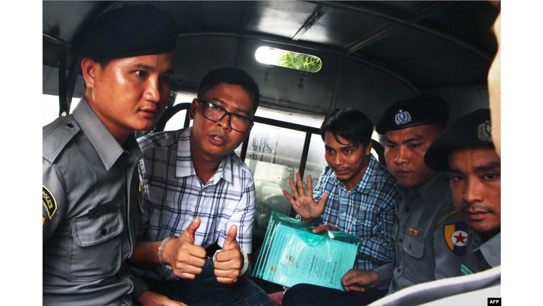 FILE - Detained Myanmar journalists Wa Lone, (L) and Kyaw Soe Oo (3rd-R) are escorted by police from the courthouse as they are taken to prison after the first day of trial in Yangon, July 16, 2018.