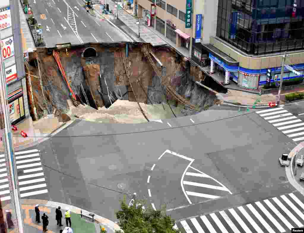 A huge sinkhole is seen at an intersection near Hakata station in Fukuoka, Japan, Nov. 8, 2016, in this photo taken by Kyodo.