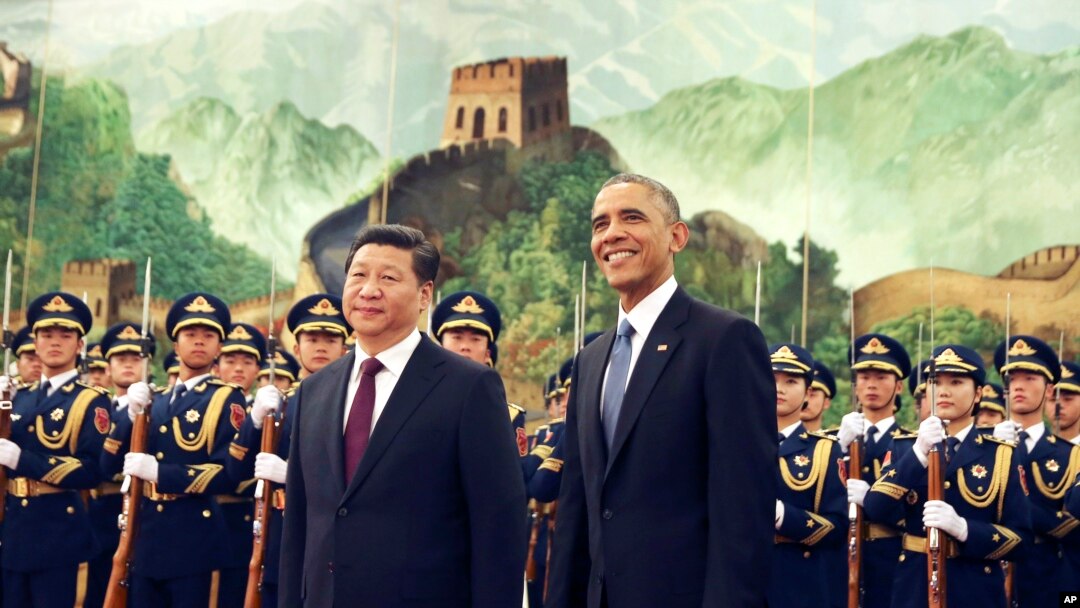 FILE - U.S. President Barack Obama, right, smiles after a group of children waved flags and flowers to cheer him during a welcome ceremony with Chinese President Xi Jinping at the Great Hall of the People in Beijing, China, Nov. 12, 2014.