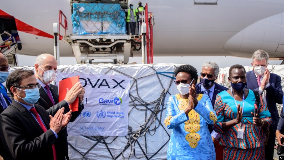 Uganda's Minister of Health Dr. Jane Ruth Aceng, center right, and other officials greet the country's first consignment of AstraZeneca COVID-19 vaccine manufactured by the Serum Institute of India at the airport in Entebbe, Uganda March 5, 2021.