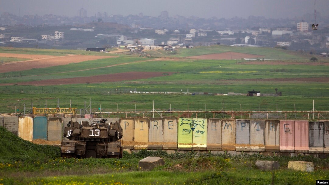 An Israeli tank is positioned outside the northern Gaza Strip, March 13, 2014.