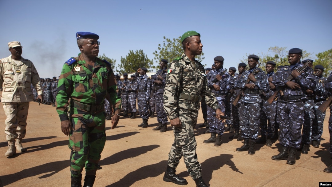 Ivory Coast army chief-of-staff Soumaila Bakayoko (L) and Malian army chief-of-staff Ibrahima Dahirou Dembele (C) inspect Malian troops at an air base in Bamako, January 16, 2013. 
