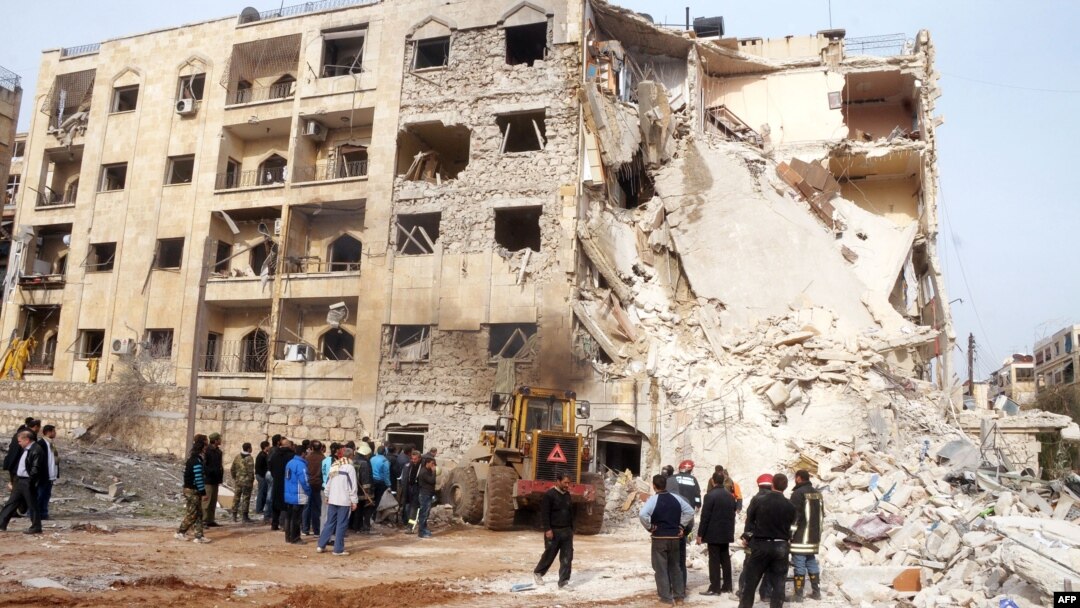 Syrians gather next to the scene of an explosion in Aleppo, January 18, 2013.
