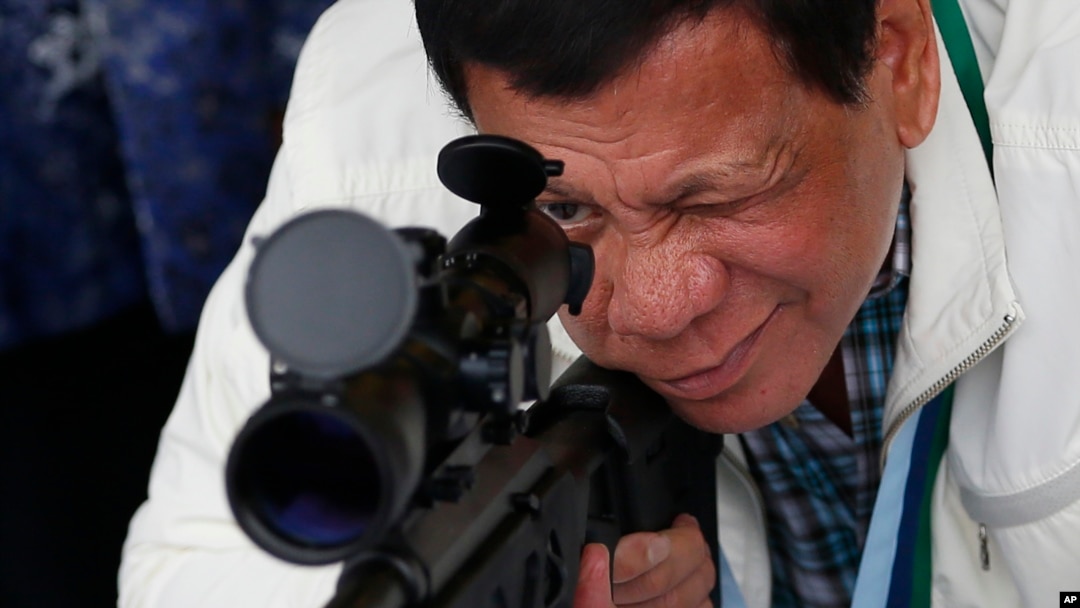 In this June 28, 2017 photo, Philippine President Rodrigo Duterte checks the scope of a Chinese-made CS/LR4A sniper rifle.