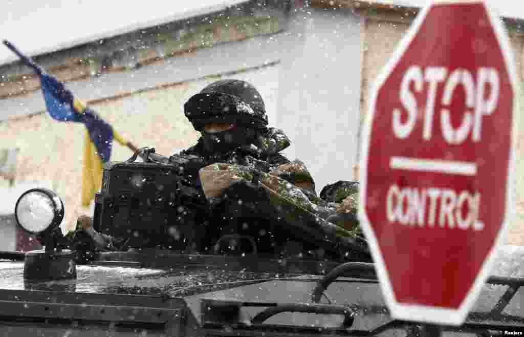 An armed man, believed to be a Russian serviceman, stands guard outside a Ukrainian military base in Perevalnoye, near Simferopol March 16, 2014.