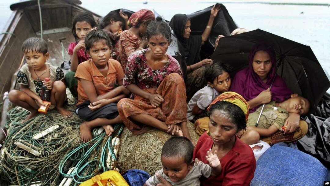 Rohingya Muslims who fled Burma to Bangladesh sit in a boat after being intercepted by Bangladeshi border authorities in Taknaf, Bangladesh, June 13, 2012.