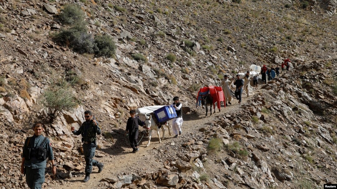 Afghan men lead donkeys loaded with ballot boxes and other election material to be transported to polling stations which are not accessible by road in Shutul, Panjshir province, Afghanistan, Sept. 27, 2019.