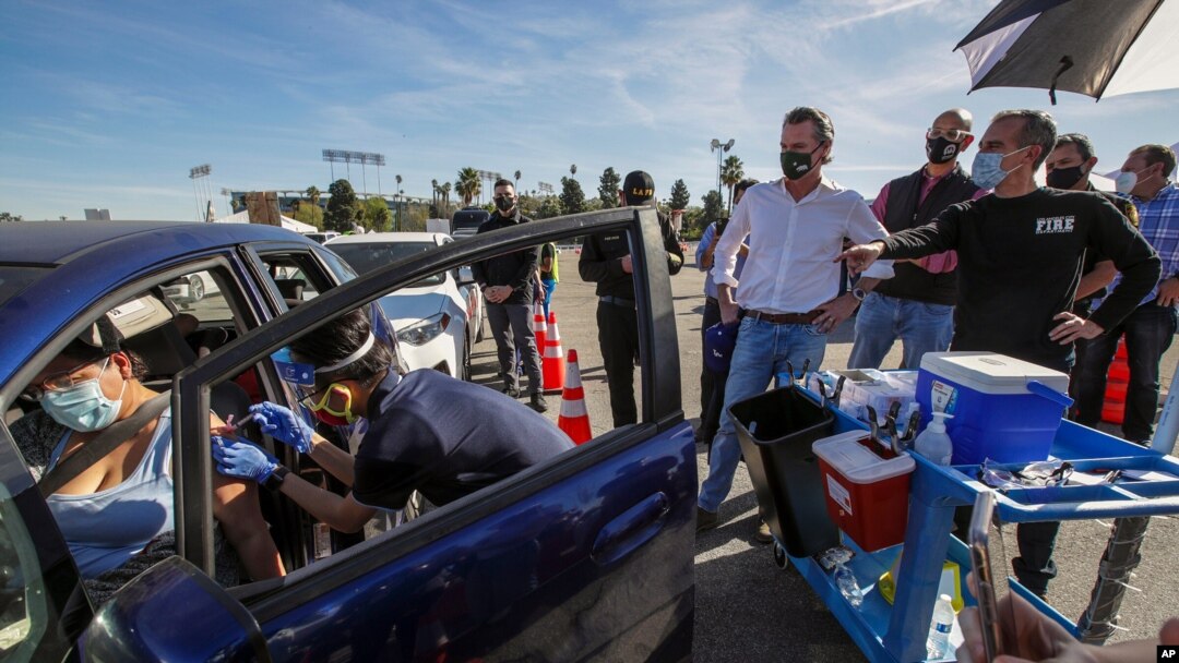 In this Jan. 15, 2021, file photo, Los Angeles Mayor Eric Garcetti, right, and Governor Gavin Newsom tour the mass COVID-19 vaccination site at Dodger Stadium in Los Angeles.