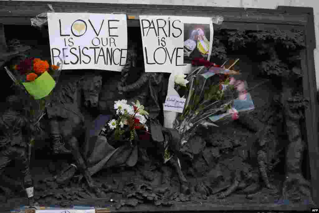 Signs reading &#39;Love is our resistance&#39; and &#39;Paris is love&#39; are pictured at the Monument a la Republique, at the Place de la Republique in Paris, on Nov. 15, 2015, two days after a series of deadly attacks.