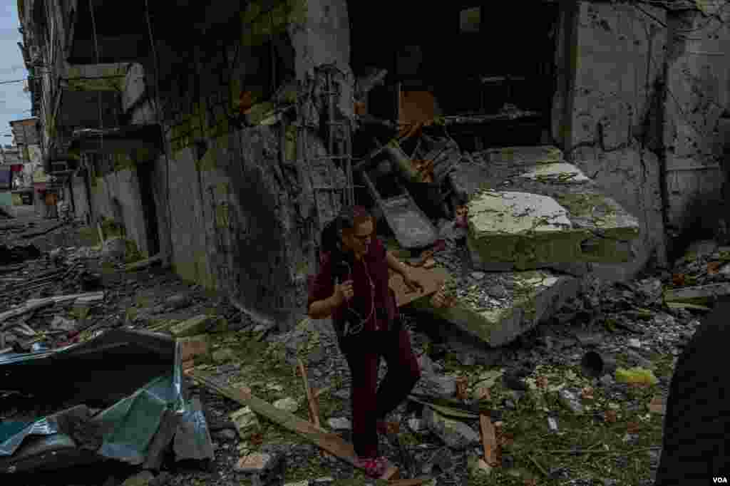 A woman walks through a housing complex destroyed in recent battles, in Nagorno Karabakh, Oct. 10, 2020. (Yan Boechat/VOA)