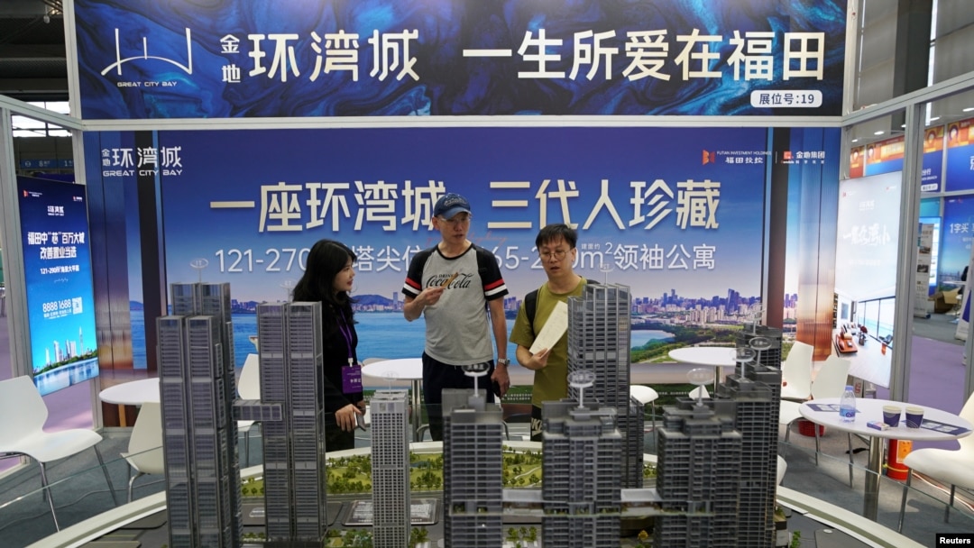 中國廣東省深圳市一個房地產博覽會的推銷員正在向客戶介紹樓型。 （2024年10月12日）