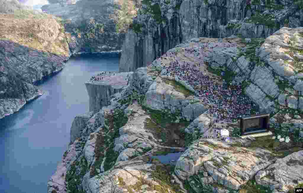 People gather in the mountains near Preikestolen (The Pullpit Rock) in Forsand near Stavanger, western Norway, Aug. 1, 2018, to see the movie "Mission: Impossible — Fallout."