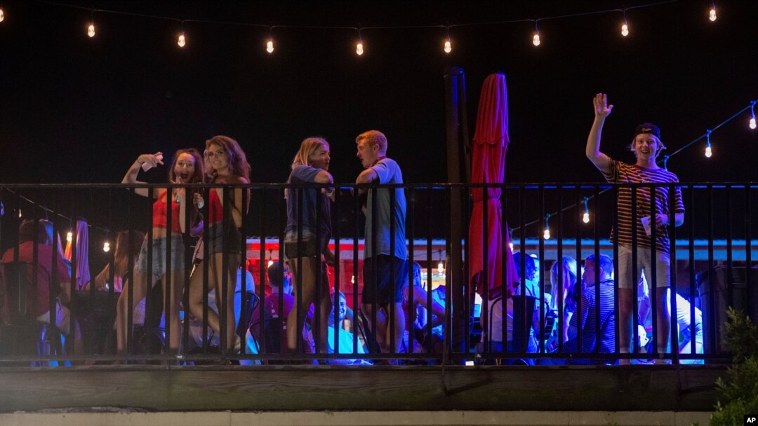 Patrons stand on the Bear Trap's rooftop bar on The Strip, the University of Alabama's bar scene, Aug. 15, 2020, in Tuscaloosa, Alabama.
