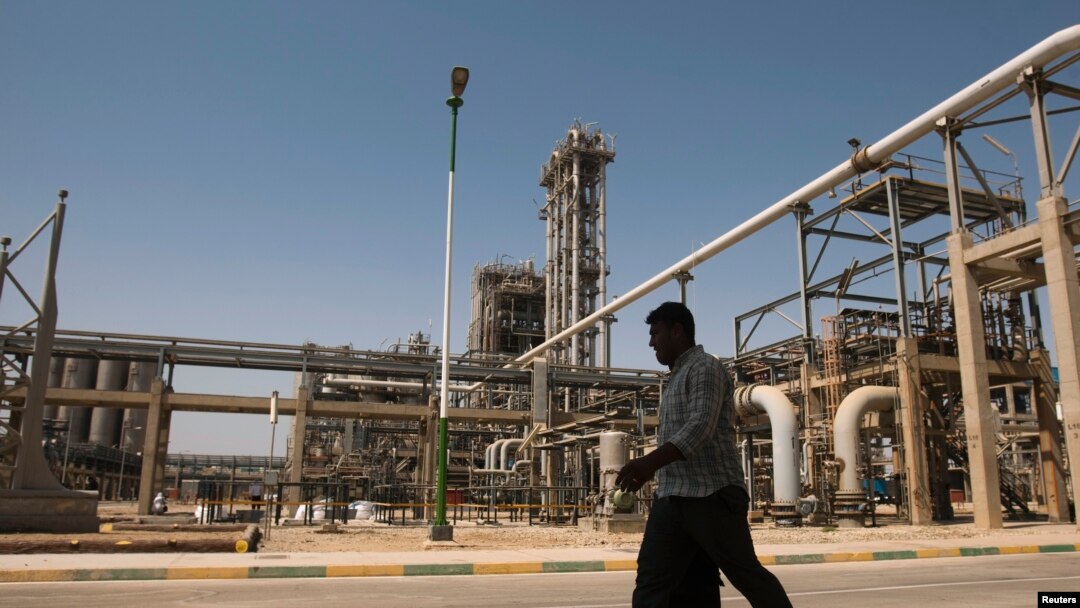 FILE - A man walks past the Mahshahr petrochemical plant in Khuzestan province, southwest of Tehran, Iran, Sept. 28, 2011.