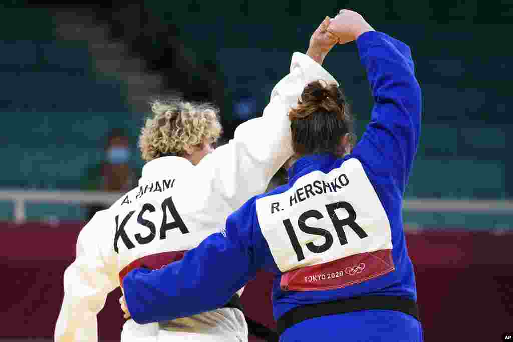 Tahani Alqahtani of Saudi Arabia, left, and Raz Hershko of Israel react after competing in their women's +78kg elimination round judo match at the 2020 Summer Olympics in Tokyo, Japan.