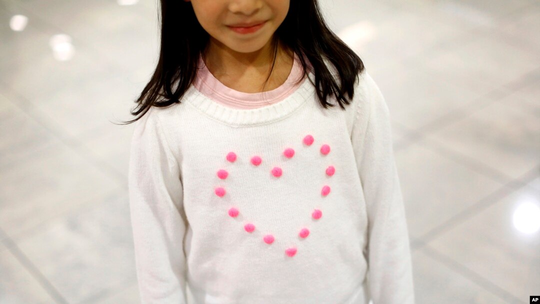 FILE - Janet Mejia, 7, wears a sweater bearing a heart as she waits for two siblings to arrive from El Salvador in Linthicum, Md., Nov. 12, 2015. They were among the first teens to receive permission to travel legally to the U.S. via the Central American Minors program.