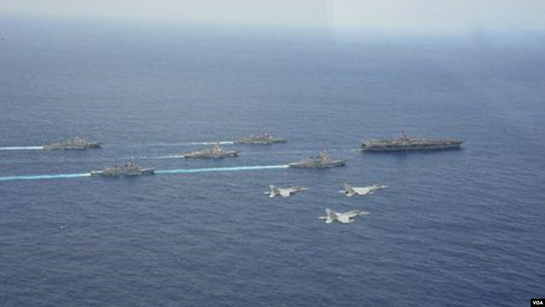 4月28日在沖繩附近海域，日本兩艘軍艦和兩架F15戰機參加美國核航母“卡爾·文森”號為首的美軍戰艦群和航母搭載機聯合軍演時的布陣航行、飛行環節（日本航空自衛隊提供）