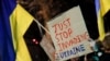 A person holds up a placard during a pro-Ukrainian demonstration outside the Russian Embassy, in London, Britain, Feb. 23, 2022. 