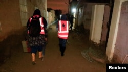 FILE - Director of the Toxic Organism Research Center Dr. Rania Mohamed, and Dr. Manal Siyam search for snakes and scorpions on Tuti Island in Khartoum, Sudan, Sept. 12, 2022.