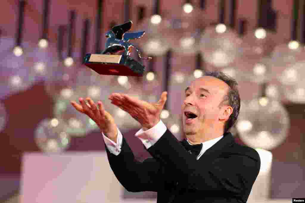 Actor Roberto Benigni poses with a Golden Lion award for lifetime achievement on the red carpet during the 78th Venice Film Festival in Venice, Italy, Sep, 1, 2021.