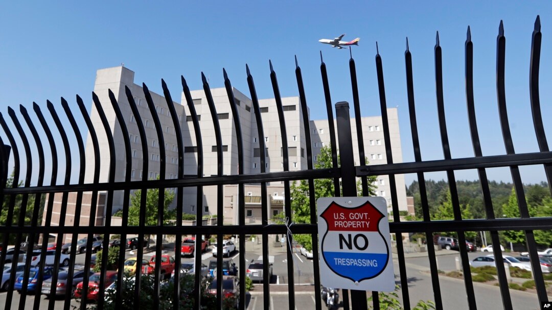 The Federal Detention Center where Blanca Orantes-Lopez is held 3,000 miles away from her child is seen behind a fence as a jet flies overhead, June 19, 2018, in SeaTac, Wash. The woman from El Salvador sits in the federal prison south of Seattle, having reported to immigration authorities after crossing the U.S.-Mexico border illegally in Texas. Her son, Abel Alexander, is in the government's custody at a children's home in Kingston, New York. She has no idea when she might see her child, one of about 2,000 children President Donald Trump's administration has taken from their parents as it cracks down on illegal immigration.