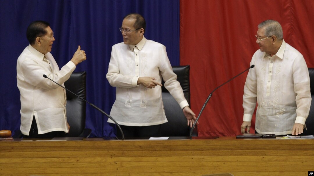 Philippine President Benigno Aquino III, center, is given a thumbs-up sign by Senate President Juan Ponce Enrile, left, while House Speaker Feliciano Belmonte looks on, after he delivers his third State of the Nation address Monday July 23, 2012. 