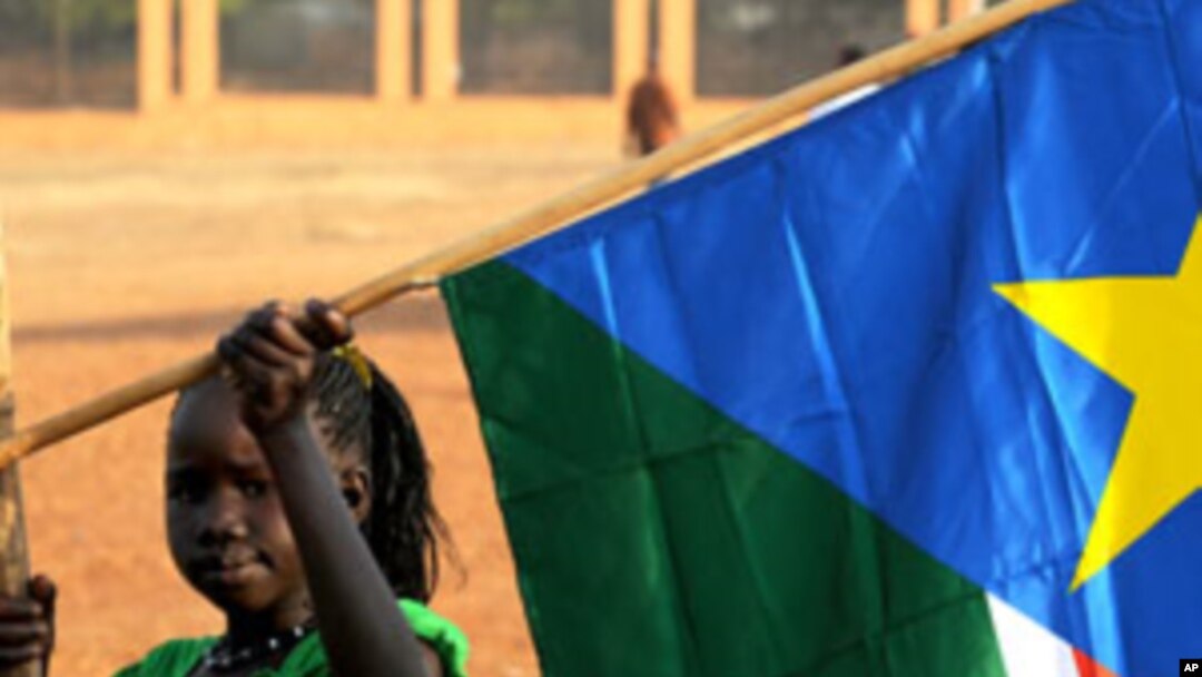 A girl holds a South Sudan flag on January 30 during the announcement of the preliminary results of voting on independence