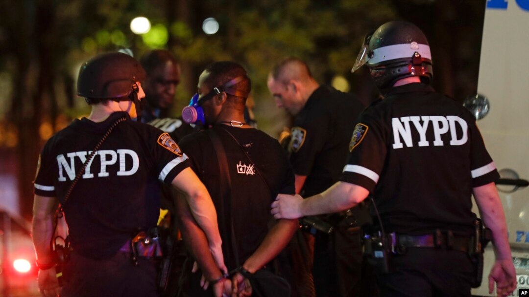 New York Police Department officers escort a protester after he was arrested at a rally calling for justice over the death of George Floyd, in the Brooklyn borough of New York, June 3, 2020. 