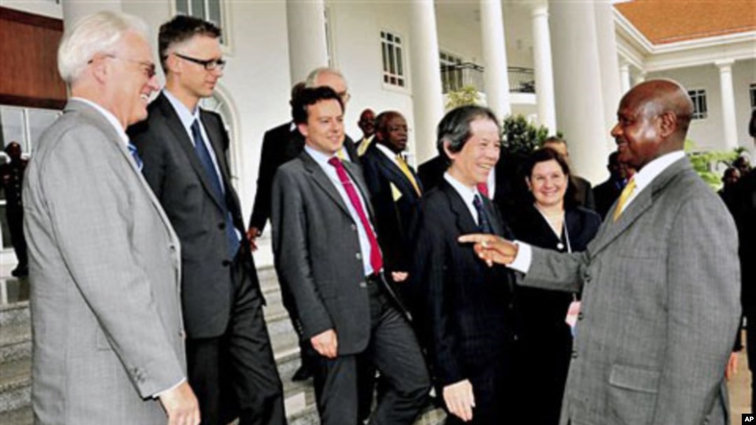 Uganda President Museveni (R) talks to UK Mission to the UN Ambassador Mark Lyall Grant (L) as members of the UN Security Council look on at State House Entebbe, Uganda, 06 Oct. 2010