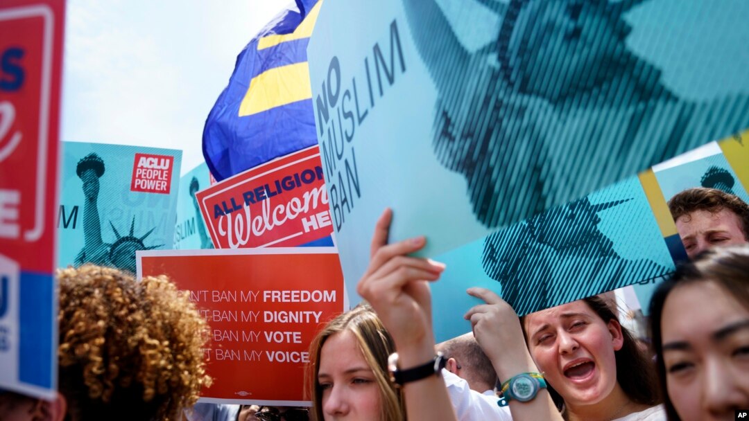 Protesters rally against the Supreme Court ruling upholding President Donald Trump's travel ban, outside the Supreme Court in Washington, June 26, 2018. 
