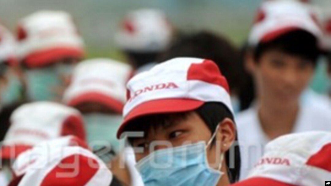 Chinese factory workers wearing masks gather during a strike at an auto parts plant of Honda in Foshan city, south Chinas Guangdong province, 26 May 2010