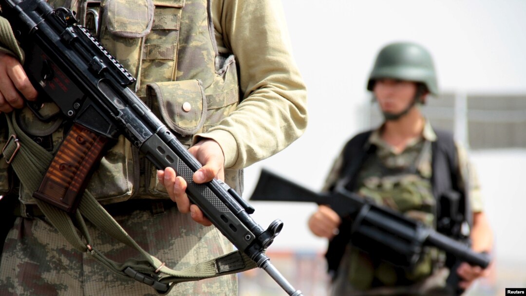 FILE - Turkish soldiers stand guard at a check point on the main road between Mardin and Cizre in southeastern Turkey, Sept. 9, 2015. 