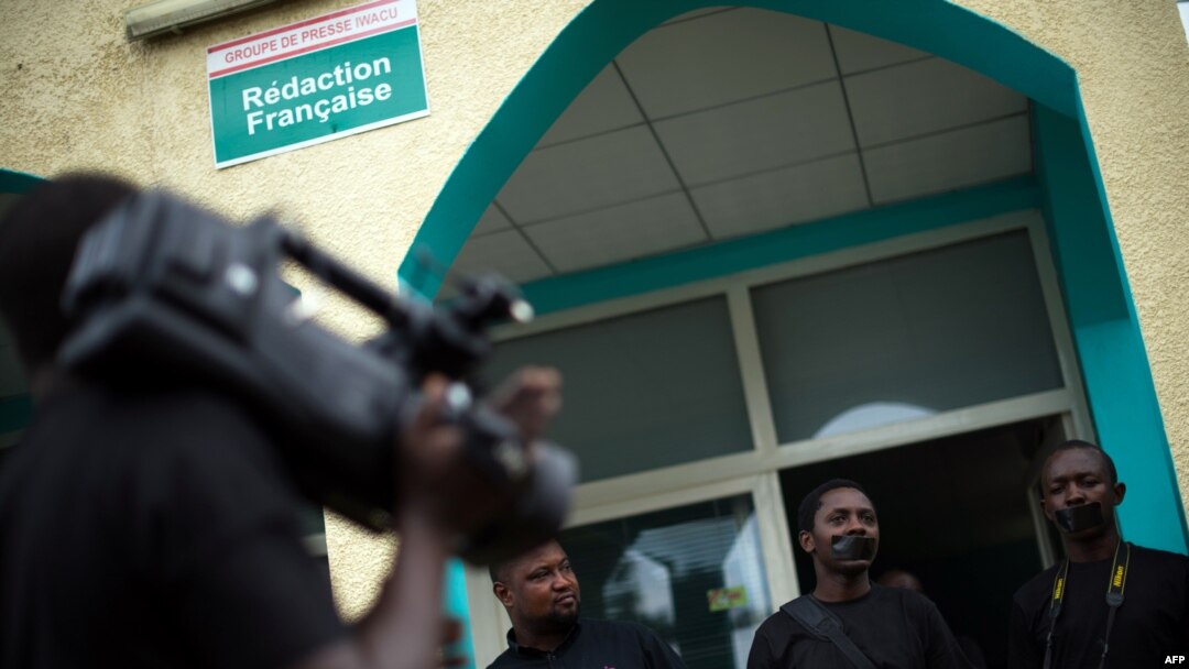 FILE - People with black tape on their mouths attend a press conference of local journalists to mark World Press Freedom Day at the offices of the Iwacu media group in Bujumbura, Burundi, May 3, 2015. 