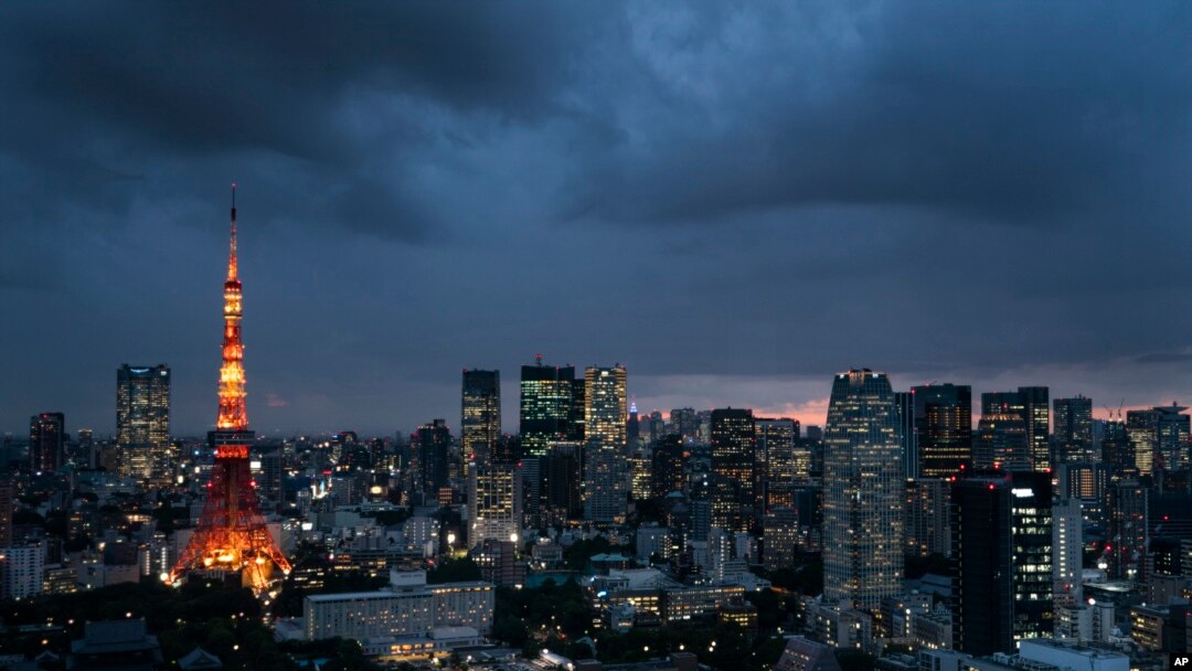FILE- The Tokyo Tower is lit up at dusk as rain clouds hover over the city's skyline, in Tokyo, Japan, May 29, 2019. The U.N.'s climate chief Patricia Espinosa on Tuesday chided Japan over its new plan to reduce greenhouse gas emissions.