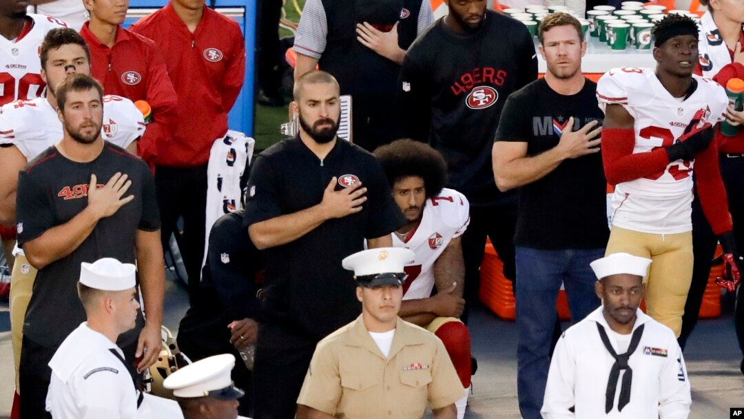San Francisco 49ers quarterback Colin Kaepernick, middle, kneels during the national anthem before the team's NFL preseason football game against the San Diego Chargers, Thursday, Sept. 1, 2016.