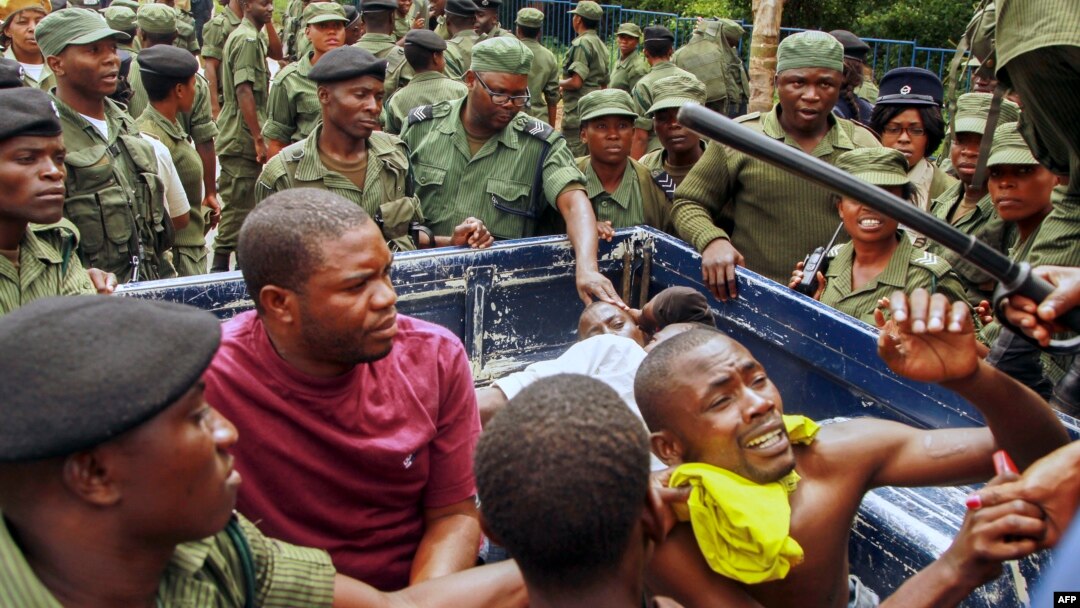 FILE - Zambian police officers apprehend supporters of the opposition United Party for National Development outside the presidential election result center at the Mulungushi International Conference Center in Lusaka, Jan. 21, 2015.
