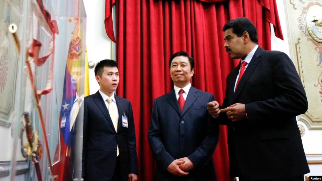 El presidente de Venezuela Nicolás Maduro le muestra al vice presidente de China Li Yuanchao la espada del héroe nacional Simón Bolívar.
