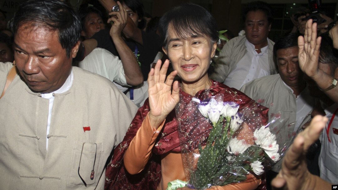 Myanmar opposition leader Aung San Suu Kyi, center, arrives at Rangoon International airport before departing for India in Rangoon, Burma Nov. 12, 2012.