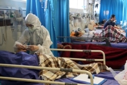 A medic treats a patient infected with the new coronavirus, at a hospital in Tehran, March 8, 2020.