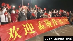 2021年9月25日，在广东深圳宝安国际机场打着横幅欢迎孟晚舟回国的人群。（路透社照片）
