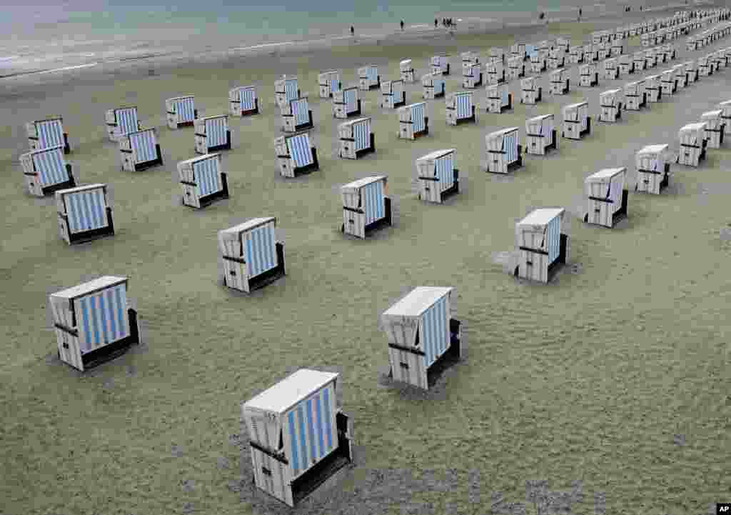 People walk along the beach in Warnemuende, near Rostock, Germany.