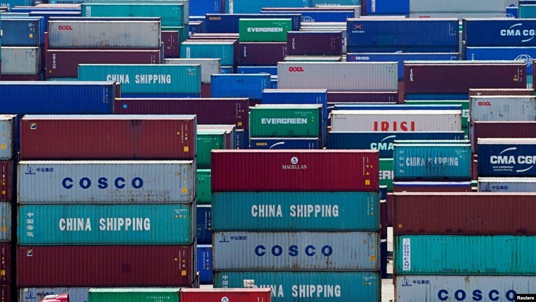 FILE - A truck carrying containers is seen near a Chinese flag at the Yangshan Deep Water Port in Shanghai, China, Aug. 6, 2019.