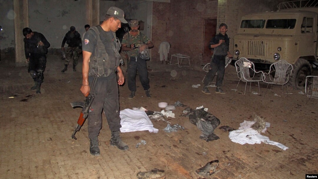 Security officials gather at the site of a suicide bomb blast in the outskirts of Dera Ismail Khan, Oct. 16, 2013. 
