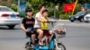 中国某城市的大街上一妇女带着两个孩子
